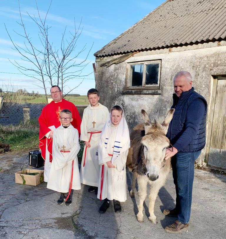 Children, priest, donkey outdoors for Palm Sunday